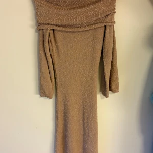 Beige långklänning från SHEIN - Säljer en beige långklänning från SHEIN med offshoulder-design och lång ärm. Klänningen har en texturerad yta och är tillverkad i polyester. Perfekt för dig som gillar stilrena och trendiga plagg.