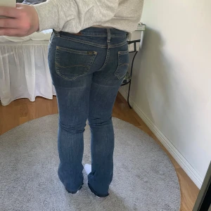 Blå bootcut jeans från Lee - Supersnygga jeans från Lee som jag sytt till mer flare. Liten fläck på fickan där bak som går att tvätta bort. W26 L33