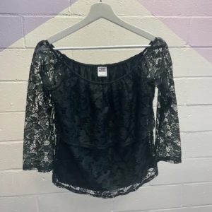 Svart spetsblus från Vero Moda - Säljer en svart blus från Vero Moda i genombruten spets med blommigt mönster. Blusen har offshoulder-modell och långa ärmar. Perfekt för dig som vill ha en romantisk och trendig look.