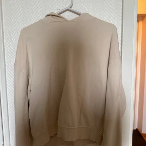Beige hoodie från H&M Basic - Säljer en enkel och stilren beige hoodie från H&M Basic. Tröjan har huva och långa ärmar, perfekt för en avslappnad look. Passar dig som gillar mjuka och neutrala färger.