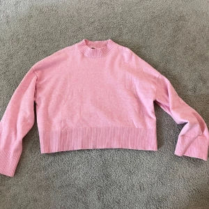 Rosa stickad tröja - Säljer en söt rosa stickad tröja med ribbade muddar. Perfekt för lager-på-lager och passar till både jeans och kjol. Enkel och stilren design som är lätt att matcha. Storlek L men passar M också och kanske S 