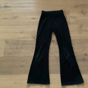 Svarta mjukisbyxor från kappahl i storlek 140 - Säljer ett par svarta manchesterbyxor från Kappahl i barnstorlek 140. Byxorna har bootcut-modell med utsvängda ben och har en stocholmstil. Perfekta för dig som gillar retrostil samt mjuka och bekväma kläder