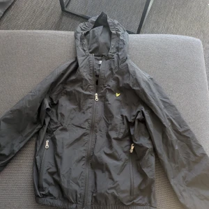 jacka från Lyle & Scott - Svart jacka med huva från Lyle & Scott. 