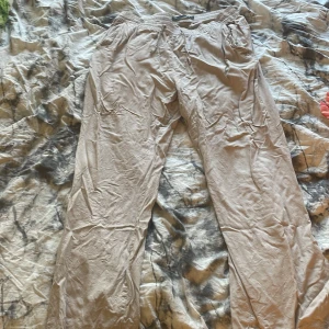 Beiga linnebyxor med resår i midjan - Säljer ett par beiga linnebyxor med avslappnad passform och resår i midjan. Byxorna har flera fickor på sidorna och är perfekta för en chill och bekväm stil. Har inte hunnit stryka dem än därför är de skrynkliga på bilden. Har snvänt dem en gång. Säljer då de inte kommer till användning