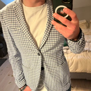 Rutig sommarkavaj - Riktigt snygg blå/vit rutig kavaj perfekt till sommaren med ett par ljusa byxor. Storlek 46/S. Fint skick utan några skador. Av märket Altatensione. 