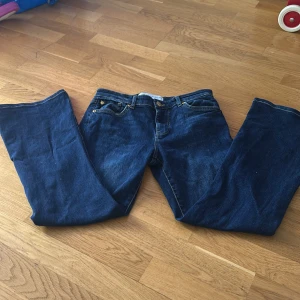 Mörkblå bootcut jeans - Säljer ett par klassiska mörkblå jeans med bootcut passform. Jeansen har fyra fickor, gylf med dragkedja och knapp samt snygga kontrastsömmar. Perfekta för dig som gillar en tidlös jeansstil.