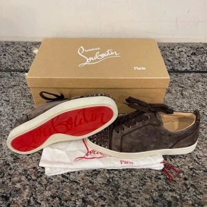  Christian Louboutin | ev byte - Säljer ett par bruna sneakers från Christian Louboutin i mocka med bruna snören och silverfärgade nitar. I mycket bra skick | bytes mot förslag 