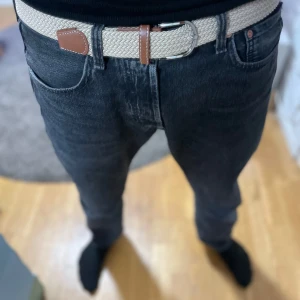 Beige flätat bälte med bruna skinn-detaljer - Säljer ett snyggt beige flätat bälte med bruna skinn-detaljer och silverfärgat spänne. Perfekt accessoar för att lyfta din outfit. Bältet har en klassisk design och passar till många olika stilar. Aldrig använt. Nytt skick!