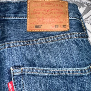 Levi's 501 jeans blå denim - Klassiska blå Levi's 501 jeans med raka ben och femficksmodell. Byxorna har knappgylf och tydlig läderpatch bak i midjan. Modellen är tidlös och passar till många olika stilar.
