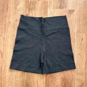 Mörkgrå korta leggings/tights/tajts/shorts - Mörkgrå shorts i stretchigt material med hög midja och enkel design. Perfekta för att ha hemma eller under klänningen/kjolen. Mjuka och bekväma med en tight passform.