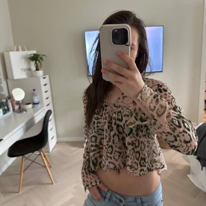 Leopardmönstrad croppad blus med volang - Säljer en trendig croppad blus i rosa med leopardmönster och volangdetaljer. Såå fin. Storlek XS från Zara