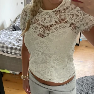 Vit spetsblus med blommönster - Fin spetstopp med lite volym i ärmarna