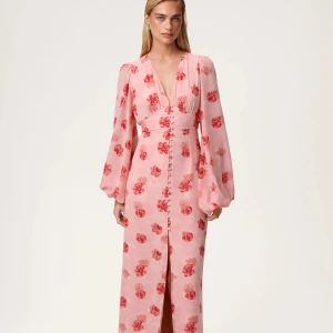 Adoore -Rosa blommig långklänning med v-ringning - HELT NY med lapparna kvar. Superfin långklänning i ljusrosa med röda blommor, djup v-ringning och långa puffärmar. Klänningen har knappar framtill och markerad midja för en snygg siluett. Perfekt för dig som vill sticka ut med romantiska vibes och flowy känsla.