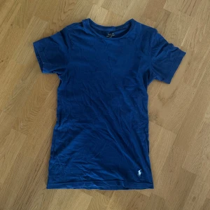 Marinblå slim fit tshirt ralph lauren  - Snygg marinblå t-shirt från Polo Ralph Lauren med klassisk broderad logga i vitt nedtill. Modellen är slim fit och har korta ärmar och rund hals. Tillverkad i 100% bomull för en skön och lätt känsla. Använd fåtals gånger! Sitter as bra på kroppen