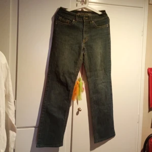 Klassiska blå jeans straight fit - Säljer ett par klassiska blå jeans med raka ben och normal passform. Jeansen har fem fickor, gul kontrastsöm och är tillverkade i slitstarkt denim. Perfekta för en avslappnad och tidlös look.
