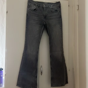 Grå lowboot jeans med utsvängda ben - Snygga gråa jeans från lager. Säljer för att jag ska sluta använda jeans. Short length