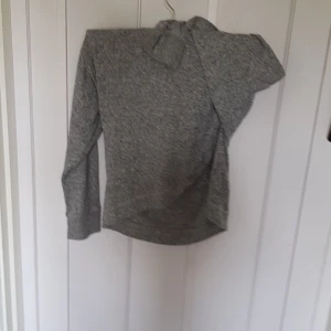 Gråmelerad hoodie från Lindex Kids - Mysig gråmelerad hoodie från Lindex Kids i storlek 134/140. Tröjan har huva, långa ärmar och är tillverkad i mjukt material som passar perfekt för kyligare dagar. Enkel och stilren design som funkar till det mesta.