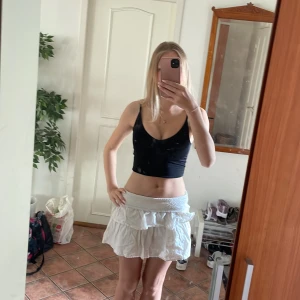 Svart croppad linne med u/v-ringning och i träningsmaterial - Ett svart croppad linne i träningsmaterial som passar perfekt nu till sommaren när det blir mer svettigt. Ger en tight och bra känsla då man håller allt på plats så att man kan träna i lugn och ro. Funkar även som sommar linne och ger en perfekt push med brösten också!