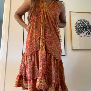 Mönstrad långklänning - Superfin långklänning i skönt silkesliknande material, köpt i Rom!😚justerbar när det gäller storleken då den knyts i ryggen (det är onesize)❤️