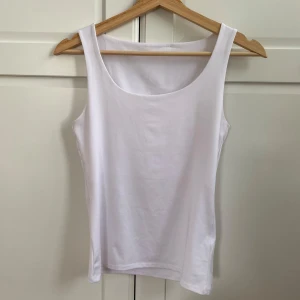 Vit topp - Vit topp i najs material. Superfin att ha med urringningen framåt eller bak och fram!🪽