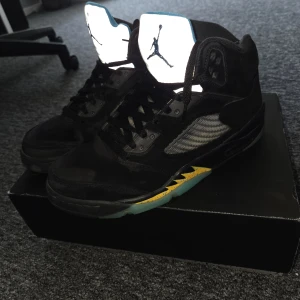 Nike Air Jordan 5 Retro svart/blå - Säljer ett par Nike Air Jordan 5 Retro med svart mocka. Köpt 2023 från GOAT (kvitto finns vid önskemål). Sparsamt använda så de är fortfarande väldigt bra kvalité. Skriv gärna vid frågor!