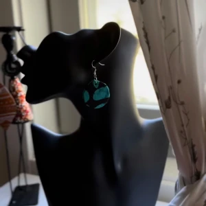 Turkosprickiga örhängen från Shop with Tyra - Coola örhängen i rund form med turkos och svarta prickar. De hänger snyggt och ger en unik touch till din stil. Perfekta för dig som vill sticka ut med accessoarer som syns. Följ oss för mer på Instagram; @shop_with_tyra