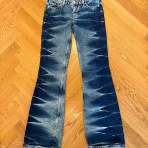 Blå bootcut jeans med tvättade detaljer - Blåa low waisted tie diy jeans från weekday! Nova  low slim bootcut jeans heter modellen!🩷 original är 650-800 kommer ej ihåg