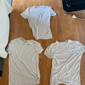 Vit basic t-shirt i bomull - Enkel vit t-shirt i klassisk modell med rund hals och korta ärmar. T-shirten är tillverkad i mjuk bomull och har en clean look utan tryck eller detaljer. Perfekt att matcha med jeans eller shorts för en avslappnad stil. Alla 3 säljs för 200kr totalt