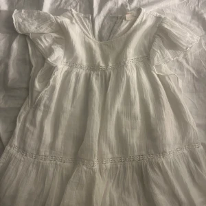 Vit blus från Gina Tricot - Luftig vit blus från Gina Tricot med volangärmar och v-ringning i ryggen. Den är i storlek 164 men passar som xs 