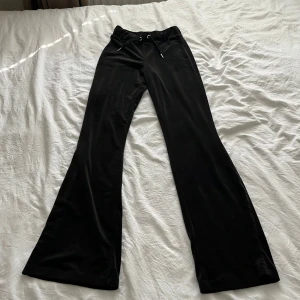 Svarta mjukisbyxor från Gina Tricot - Svarta mjukisbyxor från Gina Tricot i mjukt och lent material. Byxorna har bootcut-modell, hög midja och snörning i midjan för extra komfort. Perfekta för en chill och avslappnad stil.