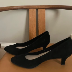 Svarta pumps  - Stilrena svarta pumps i mjuk mocka. Skorna har spetsig tå och låg klack, vilket ger en elegant och klassisk look. 🖤