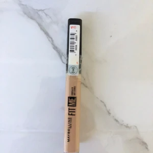 Maybelline Fit Me Concealer 10 - Maybelline Fit Me Concealer i nyansen 10. Perfekt för att täcka mörka ringar och ojämnheter. Kommer i en smidig tub med svart lock och applikator. Ljus beige färg som smälter in naturligt i huden.