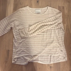 Randig långärmad tröja Samsøe Samsøe - Ljusbeige och vit randig långärmad tröja från Samsøe Samsøe. Tröjan har en avslappnad passform, rund halsringning och är tillverkad i mjuk bomull. Perfekt för en chill och stilren look.