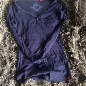 Mörkblå långärmad topp från edc - Mörkblå långärmad topp från edc by Esprit med v-ringning och tre knappar framtill. Tunn och mjuk i bomull, perfekt för lager-på-lager. Snygg passform och enkel att matcha med jeans eller kjol.