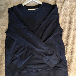 Mörkblå sweatshirt Tommy Hilfiger - Mörkblå sweatshirt från Tommy Hilfiger i klassisk modell med rund hals och ribbade muddar. Tröjan är i mjuk bomull och har en liten broderad logga framtill. Perfekt för en chill och stilren look.