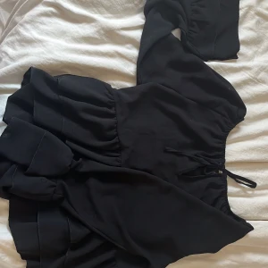 Svart bluss - Supersöt svart blus från Missäy med långa vida ärmar och volangdetaljer. Mannan ha den både off sholder och som vanligt. Storlek S/XS ( knappt andvänd )
