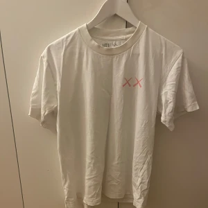 Vit KAWS x Uniqlo t-shirt S - Tja! Säljer nu denna Kaws x uniqlo T-shirten då jag har vuxit ur den. Tröjan är i perfekt skick och är i Storlek S. Tveka inte på att höra av dig!