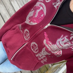 Aim for the moon hoodie - Säljer en zip hoodie med dragkedja och huva. Framsidan har stora strasstenar i silver och rosa som bildar texten 'AIM FOR THE MOON' och motiv av en tecknad figur och måne. Jackan har känguruficka och är i mjukt bomullsmaterial. Perfekt statement-plagg för dig som gillar unika detaljer. Oanvänd! Endast testad, säljer för har ej användning för den vill bara bli av med den. Priset kan diskuteras💓💓