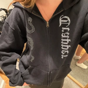 MadeByTrappers hoodie - Svart hoodiejacka med dragkedja och huva, dekorerad med strassorm och text framtill med en loose passform.