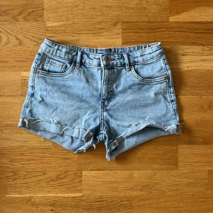Ljusblå jeansshorts med fransig kant - Snygga ljusblå jeansshorts med fransig, rå kant och klassisk femficksdesign. OBS! De är stora i storleken så passar 1-2 storlekar större också.