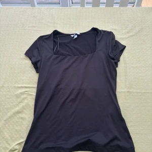 Svart kortärmad topp - Säljer en stilren svart topp med korta ärmar och fyrkantig halsringning. Perfekt för en enkel och elegant look. Det finns 2 stycken💕har aldrig använt💕💕