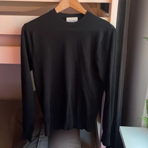Svart långärmad tröja från Sandö - Säljer en stilren svart långärmad tröja från Sandö. Endast använd fåtal gånger och har inga defekter. Slim passform.