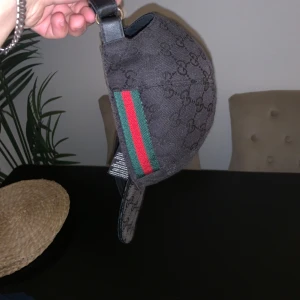Svart keps från Gucci - Äkta Gucci keps ! , säljer nu min keps den är en gammal modell ( se etiketter ) det är i bra skick men finns lite slitningar här och där , säljs för 1700 kr men kan gå ner i pris ! 