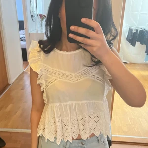 Vit blus med spetsdetaljer - Säljer en söt vit blus med spetsdetaljer och volanger. Blusen är från Zara och i storlek M men sitter mer som en S. 
