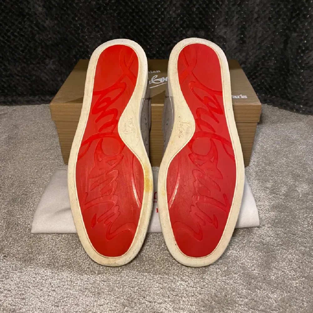 Snygga grå sneakers från Christian Louboutin i mocka med den ikoniska röda sulan. Skorna har snörning och en stilren design som passar perfekt för en trendig look. Levereras med originalförpackning och dustbag. Byten funkar men helst pengar. Kengät.