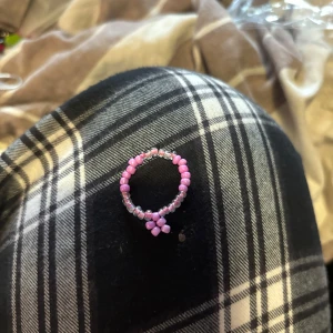 Rosa pärlring - Söt handgjord ring med små rosa och genomskinliga pärlor. Perfekt för att ge en färgglad touch till din outfit. Ringen är elastisk och passar de flesta storlekar.