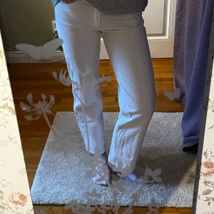 Vita jeansbyxor - Snygga vita jeansbyxor med en straight passform. Perfekta för en stilren look. De har en klassisk design med knapp och dragkedja framtill. Frakten ingår inte 