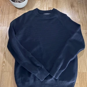 Svart stickad tröja - Säljer en stilren svart stickad tröja från primark Tröjan har en klassisk design med rund hals och långa ärmar. Perfekt för både vardag och mer uppklädda tillfällen.