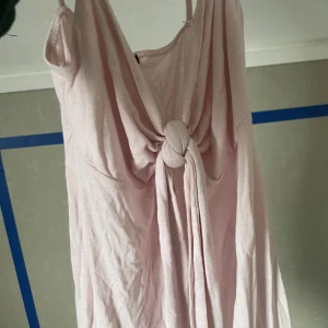 Ljusrosa linne från Gina Tricot - Säljer ett söt ljusrosa linne från Gina Tricot i storlek XS. Linnet har en knutdetalj framtill och smala axelband. Perfekt för varma sommardagar!