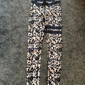 Leopardmönstrade tights från Stronger - Snygga leopardmönstrade tränings tights från Stronger. Perfekta för träning. Elastiskt material som ger en bekväm passform. 